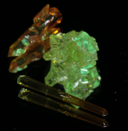 Zincite Crystals under UV light, showing green and orange fluorescent glow.